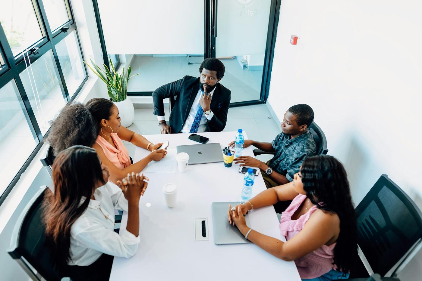 A team meeting around a table with laptops